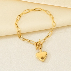 Detail of 18K gold plated paperclip chain bracelet with heart charm and toggle clasp