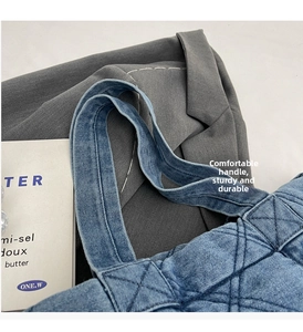 Gros plan d'un sac cabas en jean matelassé bleu avec des poignées épaisses et des losanges