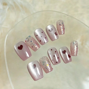 Pink heart cat eye press-on nails with glitter on fuzzy white background