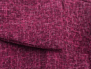 Macro shot of dark magenta tweed fabric with black and white woven texture detail