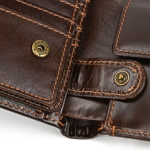 Detailed close-up of dark brown genuine leather texture with orange contrast stitching