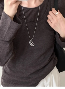 Detail of silver comb pendant necklace on snake chain with matching wide open ring