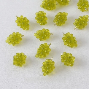 Macro detail of translucent green grape resin charms for DIY jewelry making and crafts