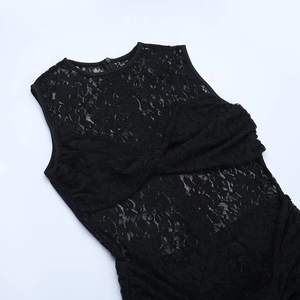 Detail of black lace dress showing cross-pleated neckline and intricate crochet texture