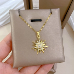Nahaufnahme einer goldenen Sonnenblumen-Halskette mit funkelnden Diamanten auf Seidenkissen