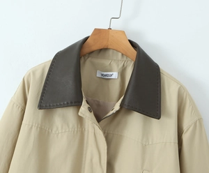 Detail of vintage khaki windbreaker with contrast brown leather collar and zipper