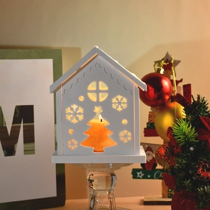 Detail of Christmas house candle holder with cutout snowflakes and LOVE engraving