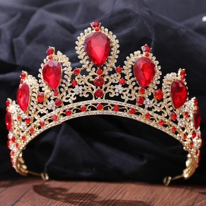 Close-up of golden bridal crown with large red teardrop crystals and fine rhinestones