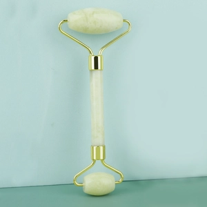 Detailed view of dual-head jade facial roller with green stone and gold metal frame