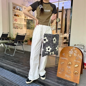 Détail du sac cabas floral en toile avec étiquette Suzzaka et style urbain chic