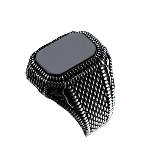 Detail of vintage men's silver ring featuring black onyx and textured braided band
