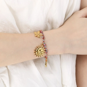 Bohemian hand-woven colorful rope bracelet with gold sun and flower pendants on a wrist