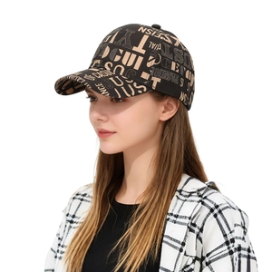 Close-up of a street style baseball cap featuring cream letter graffiti on black fabric