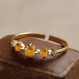 Macro detail of vintage gold S925 sterling silver ring with yellow gemstones and tiny diamonds