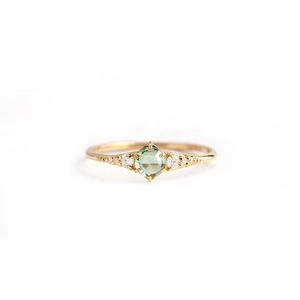 Macro shot of gold S925 sterling silver ring with square green opal and side diamonds
