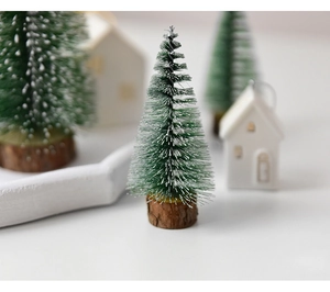 Close-up of mini snowy cedar tree with artificial white snow on a natural wood base