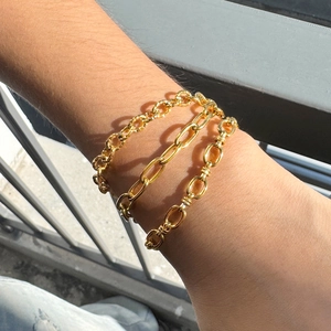 Ensemble de trois bracelets en acier inoxydable doré porté au poignet à l'extérieur