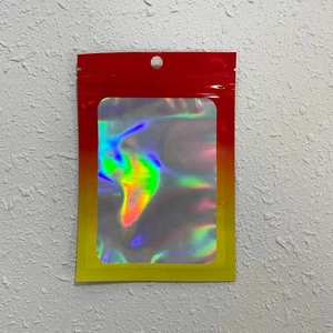 Close-up of laser holographic packaging bag with red-yellow gradient and resealable zip
