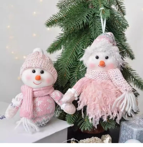 Close-up of pink knit snowman plush doll hanging on a Christmas tree branch