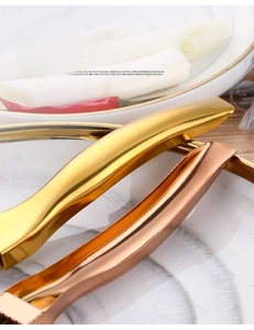 Close-up of golden stainless steel chopstick holder with curved hollow handle design