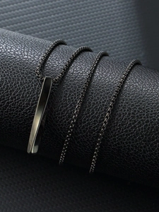 Detailed macro view of black stainless steel rectangular bar pendant with box chain