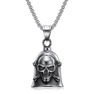 Close-up of vintage silver skull cross bell pendant showing detailed metal textures