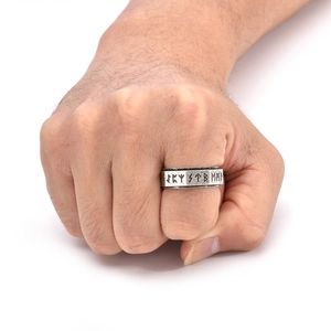 Macro detail of men's vintage Viking rune ring in brushed stainless steel on hand