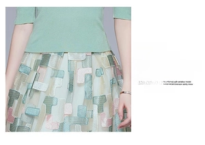 Detail view of white tulle skirt with colorful geometric embroidery and light green knit top