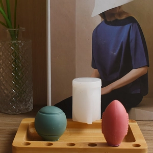 Detailed view of sphere candle molds with finished ball-shaped soaps on a wooden tray