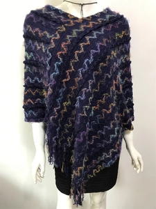 Détails d'un châle en tricot bleu foncé avec motifs de vagues colorés et franges