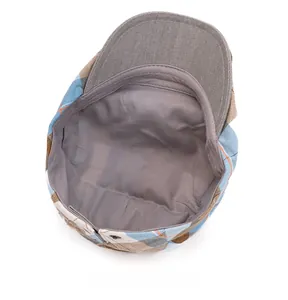 Detail view of colorful plaid ivy cap featuring soft inner lining and metal buckle closure