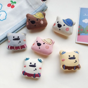 Detailed view of six colorful cartoon bear plush brooches in various embroidered styles