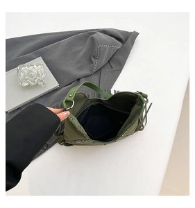 Top view of green suede tote bag featuring fringe tassels and metal rivet details