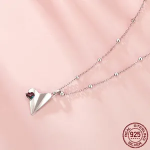 S925 sterling silver paper plane necklace with heart crystal on pink silk background
