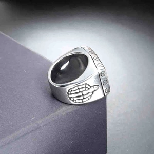 Detail of vintage silver skull hand gesture ring with matte finish and side engravings