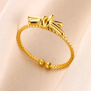 Detail of gold-plated knot ring featuring a twisted band and adjustable open design