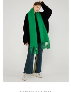 Detail shot of bright green knit scarf with chunky tassels for winter styling