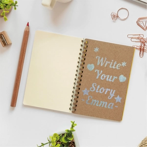 Detail of kraft paper spiral notebook with thick cream pages and golden metal coil binding