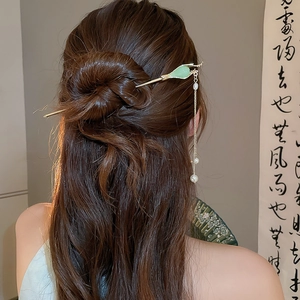 Détail d'un chignon avec épingle à cheveux feuille verte et pampille de perles