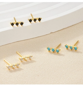Close-up of gold-plated S925 silver stud earrings set with black, turquoise, and clear zircon