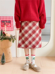 Détail de chaussettes de Noël rouges avec jupe à carreaux et chaussures en peluche douce