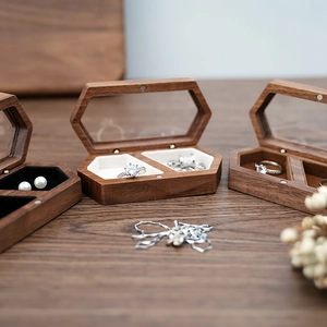 Detail of hexagonal walnut wood jewelry box with glass lid and soft velvet interior lining