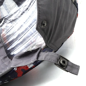 Detailed macro view of camo mesh cap showing adjustable metal snap and inner lining