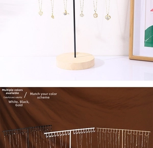 Detailed view of T-shaped jewelry display stand with hooks in black, white and gold