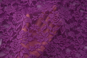 Vue détaillée de la dentelle florale violette transparente montrant la texture délicate