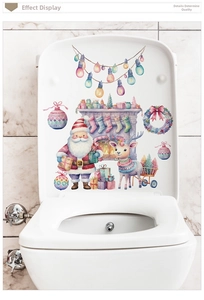 Pink Santa and reindeer Christmas stickers on a white toilet lid for festive bathroom decor