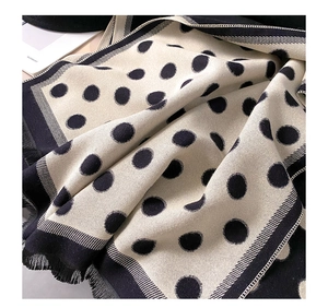 Close-up of black and white polka dot scarf with soft texture and fringe details