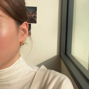 Minimalist thick gold-tone C-shaped hoop earrings on model for a trendy daily look