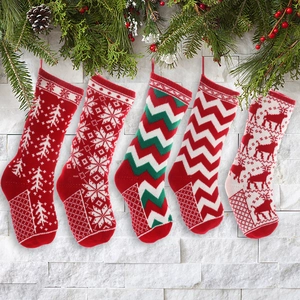 Set of 5 knitted Christmas stockings with reindeer and snowflake patterns on pine branch