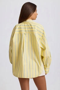 Rear view of loose casual yellow striped long-sleeve shirt with back pleat detail